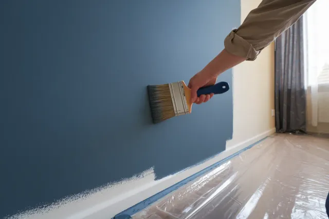 Sioux Falls homeowner applying interior paint to wall for home refresh