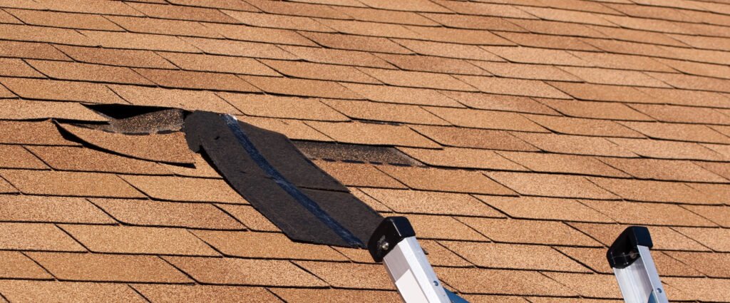 Inspecting roof for loose shingles in Sioux Falls harsh weather